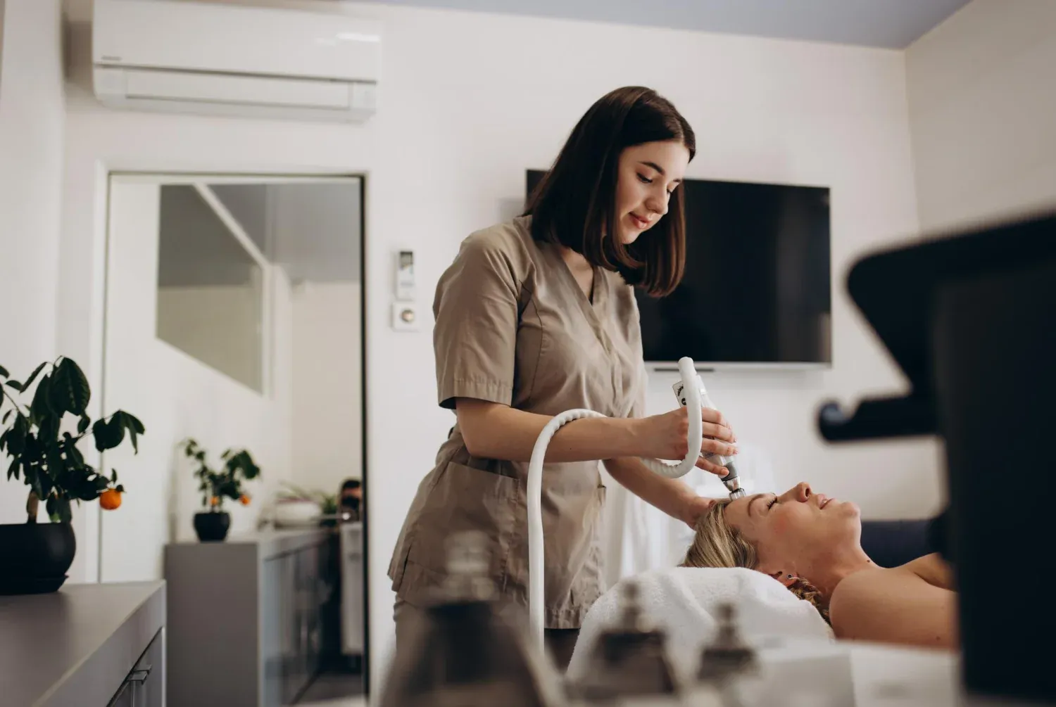 Aesthetician performing a skin treatment in a med spa treatment room